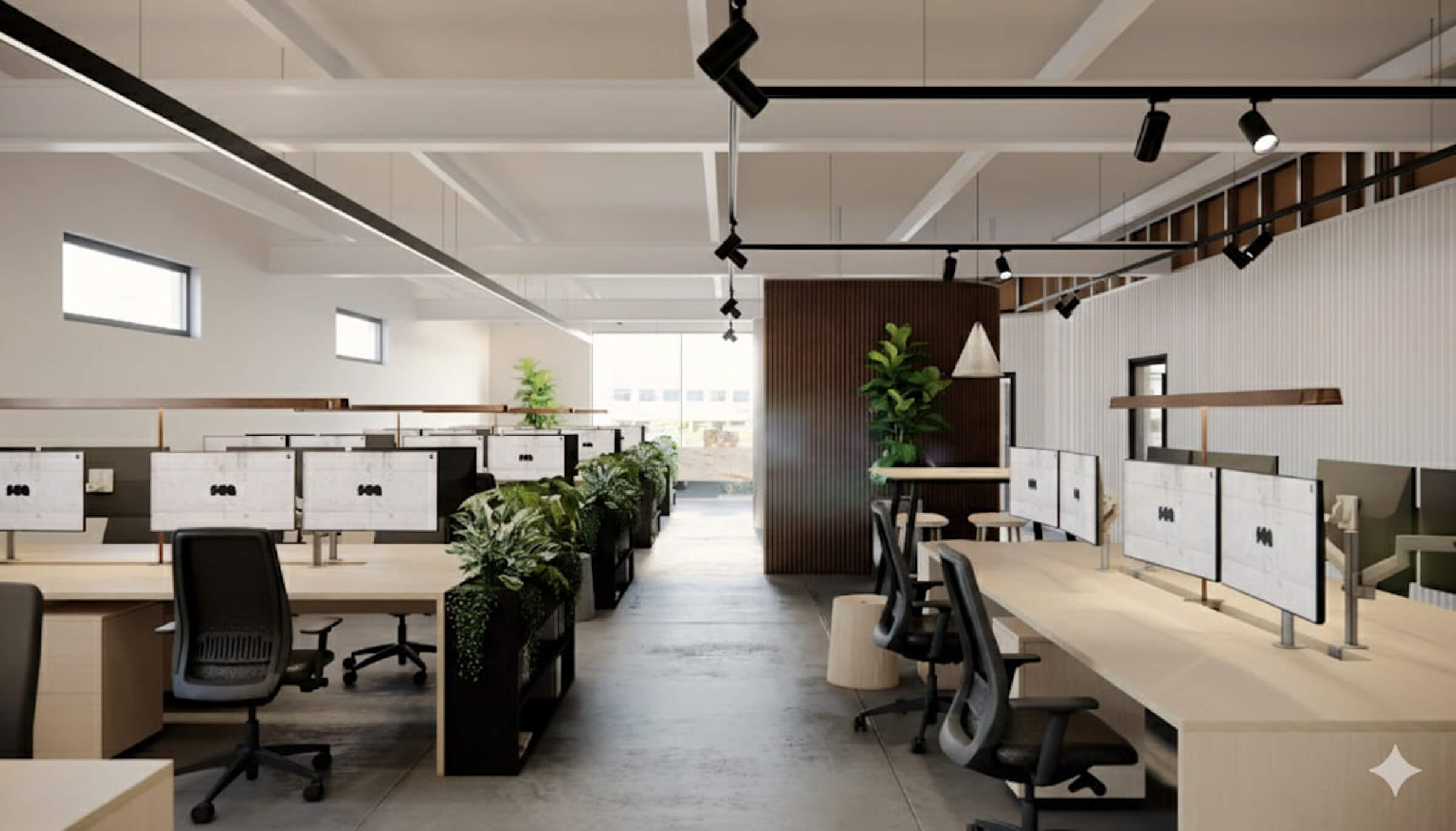 Modern office workspace with rows of desks, dual monitors, black ergonomic chairs, and abundant green plants dividing the space.